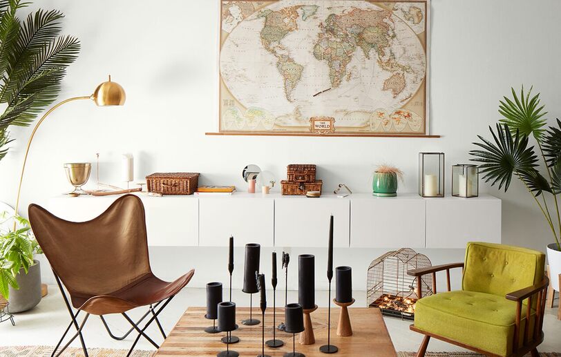 Salón luminoso de loft con paredes blancas, mapa mundial, armarios modernos, silla de mariposa Salón luminoso de loft con paredes blancas, mapa mundial, armarios modernos, silla de mariposa